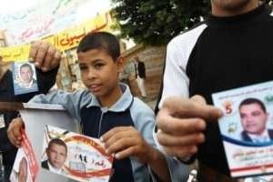 De jeunes Égyptiens distribuent des tracts pour différents candidats, le 28 novembre. © AFP