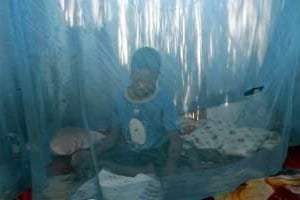 Un enfant sous une moustiquaire, pour se protéger contre le paludisme, au Mozambique en 2005. © AFP
