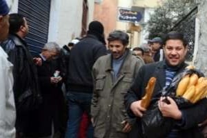 Un homme montre sa joie d’avoir réussi à acheter du pain, à Tunis le 16 janvier 2011. © AFP