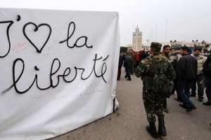Des soldats tunisiens devant une banderole « j’aime la liberté », à Sidi Bouzid, le 25 janvier. © AFP