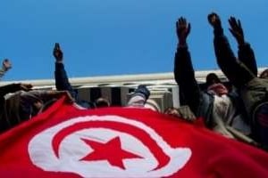 Des manifestants tiennent le drapeau tunisien, lors de la révolution, le 24 janvier 2010 à Tunis. © AFP