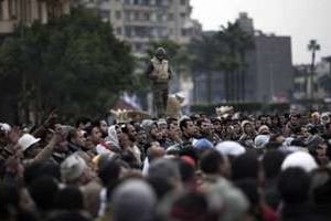 Manifestants anti-Moubarak rassemblés devant un char de l’armée sur la place Al-Tahrir au Caire. © AFP