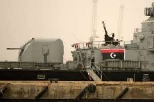 Un ancien drapeau libyen accroché sur un navire de guerre abandonné à Benghazi, le 13 mars 2011. © AFP