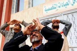 Des hommes surveillent le ciel à Ajdabiya, le 15 mars. © AFP