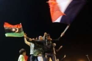 Des insurgés agitent les drapeaux de la rébellion et de la France, le 17 mars 2011 à Benghazi. © AFP