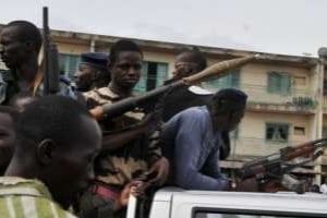 Partisans armés d’Alassane Ouattara patrouillant, le 26 mars 2011, à Abobo (Abidjan). © AFP