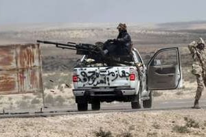 Des rebelles libyens prennent position près de Brega, le 31 mars. © AFP