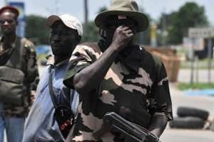 Miliciens soutenant Alassane Ouattara filtrant un barrage dans le quartier abidjannais d’Abobo. © AFP