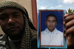 Un homme montre la photo de son frère, un civil tué dans une probable bavure de la coalition, le 2 © AFP