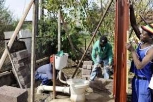 Des ouvriers construisant des toilettes, dans le Rammulotsi township (province de Free State). © Stephane de Sakutin / AFP