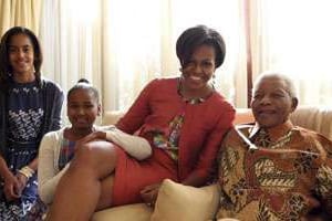 Michelle Obama et ses deux filles photographiées avec Nelson Mandela. © Reuters