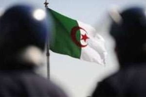 Deux policiers devant le drapeau algérien. © Farouk Batiche/AFP