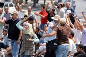 Des manifestants tunisiens scandent des slogans face aux forces de police à Tunis, le 15 juillet. © AFP