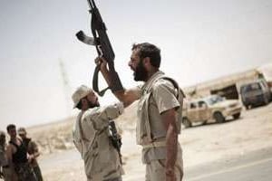 Des rebelles libyens en route pour Brega, le 19 juillet 2011, à un check-point d’Ajdabiya. © AFP