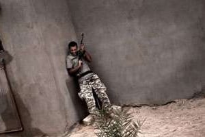 Un rebelle libyen à couvert lors d’affrontements avec un groupe de pro-Kaddafi, le 31 juillet 2011. © Colin Summers/AFP