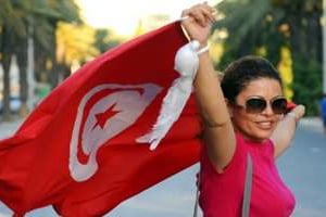 Une femme brandit le drapeau tunisien lors d’une marche contre le terrorisme et l’intégrisme à Tun © AFP