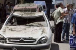 Une voiture détruite par une explosion devant un commissariat de Tizi Ouzou, le 3 août 2011. © AFP
