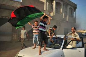Des enfants avec le drapeau de la rebellion à Al-Jamil, dans l’ouest de la Libye, le 27 août 2011. © AFP