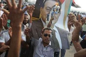 Des manifestants hostiles à Hosni Mubarak protestent lors de la reprise de son procès. © AFP