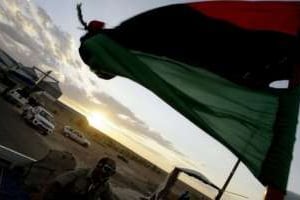 Le drapeau libyen érigé par un combattant qui se dirige vers Bani Walid, le 10 septembre 2011. © AFP