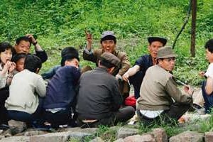 Des Nord-coréens saluant des plaisanciers chinois sur le fleuve frontalier de Yalu. © Jacky Chen/Reuters