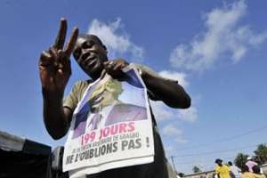 Un partisan du Front populaire ivoirien avec un journal à l’effigie de Laurent Gbagbo. © AFP