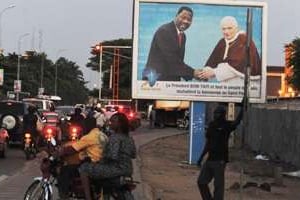 À Cotonou, une des affiches représentant le pape et le président Boni Yayi. © AFP