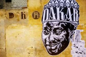 Imprimés sur du papier, les dessins des artistes couvrent les murs de Dakar. © DKR