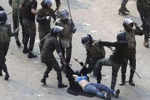 Une jeune femme arrêtée et frappée par l’armée égyptienne, samedi 17 décembre. © Reuters