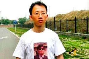 L’activiste chinois Hu Jia arborant un portrait de Chen Guangcheng, l’avocat aveugle. © How New/Reuteurs