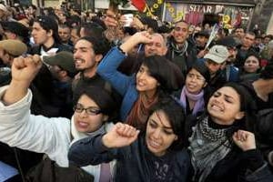 Des Tunisiens manifestent devant le siège du syndicat UGTT. © AFP
