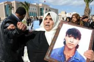 Une femme tient le portrait de son fils mort lors de la révolution, le 27 février 2012 à Tunis. © AFP