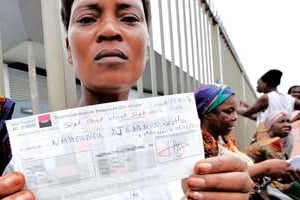 Une victime montrant son chèque d’indemnisation, en avril 2010. © Sia Kambou/AFP