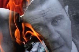 Un manifestant brûle un portrait de Bachar al-Assad. © AFP