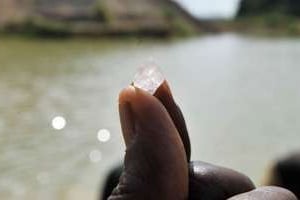 Un chercheur de diamant montre une pierre trouvée à Koidu, le 28 avril 2012. © AFP