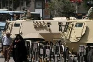 Des Égyptiens passent devant des chars de l’armée dans une rue du Caire, le 22 mai 2012. © Mahmud Hams/AFP