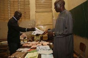 Des scrutateurs comptent les bulletins de vote à Dakar. © AFP