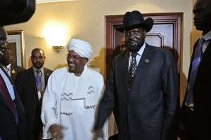 Les présidents soudanais Omar el-Béchir et sud-soudanais Salva Kiir se serrent la main. © AFP