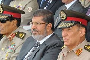 Mohammed Morsi (c) lors d’une cérémonie militaire au Caire, le 9 juillet 2012. © AFP