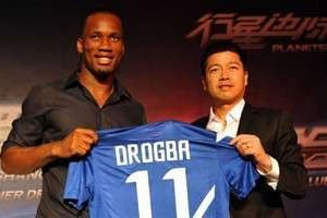 Didier Drogba (g) et le propriétaire du club de foot Shangai Shenhua, Zhu Jun, le 14 juillet 2012. © AFP