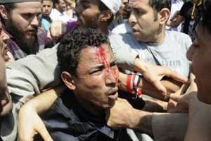 Des Égyptiens soutenant Mohamed Morsi se battent avec des opposants, sur la place Tahrir au Caire. © AFP
