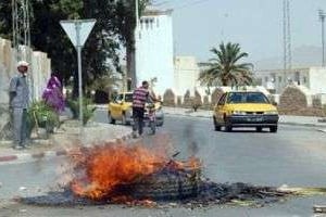 Des manifestants ont mis le feu à un pneu sur une route de Kasserine. © AFP