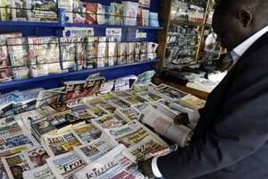 Un homme achète un journal, le 3 mai 2005 à Abidjan. © Kambou Sia/AFP