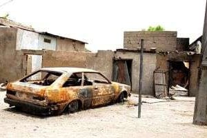 Une voiture et une maison détruites dans une explosion attribuée au groupe Boko Haram. © AFP