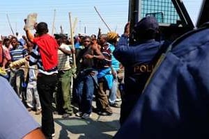 Policiers et mineurs grévistes d’Amplats se font face à Rustenburg, le 12 septembre. © AFP/Archives – Alexander Joe
