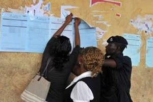 Des agents affichent les résultats d’un bureau de vote de Freetown, le 18 novembre 2012. © AFP