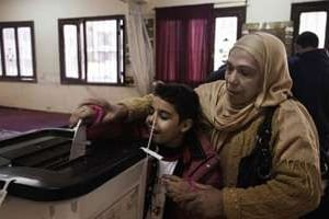 Une femme vote le 22 décembre 2010 à Guizeh, au sud du Caire. © AFP
