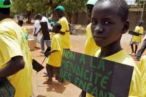 Un talibé tient une pancarte « Non à la mendicité des enfants » le 16 avril 2007 à Dakar. © AFP