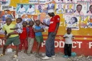 Des Kényans devant des affiches électorales à Kisumu le 6 mars 2013 © AFP