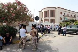 Des manifestants armés, le 29 avril devant le ministère des Affaires étrangères à Tripoli. © AFP